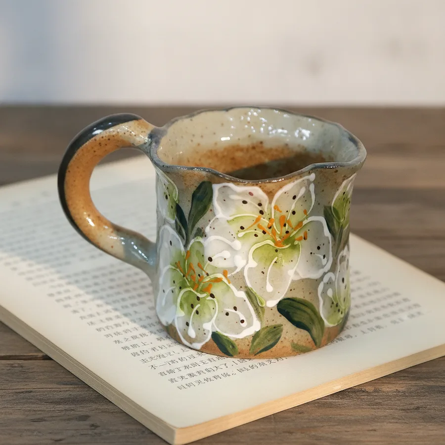 Artisan holding a handmade ceramic coffee mug in studio